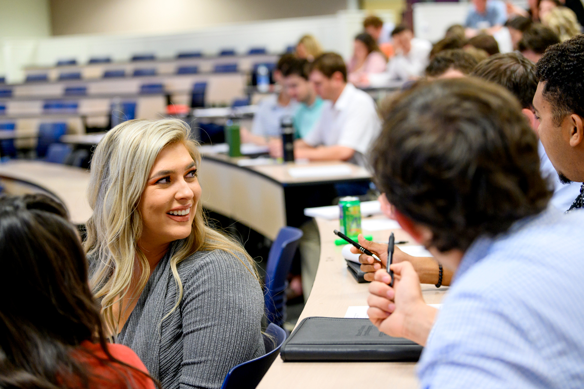 Grad students talking in a classroom