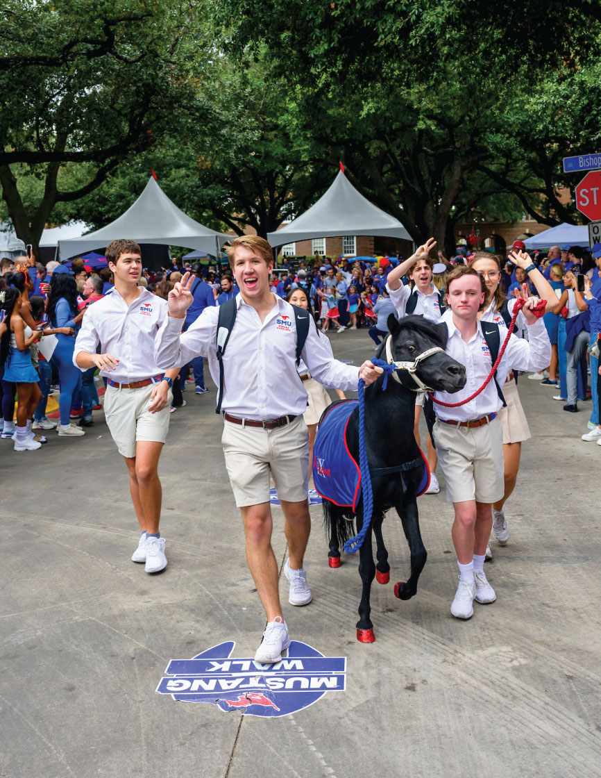 SMU students lead Peruna, the black Shetland pony, down the Boulevard during the pregame Mustang Walk.