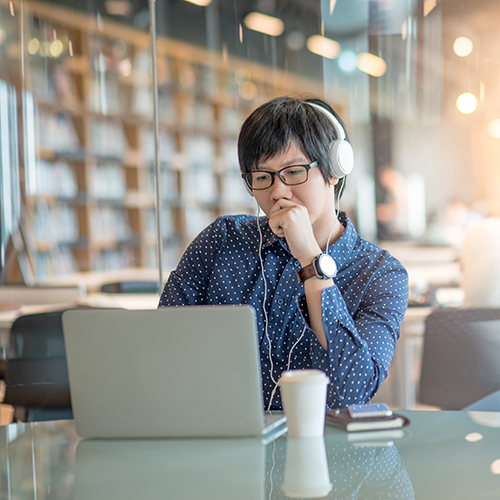 Student wearing headphones working on laptop