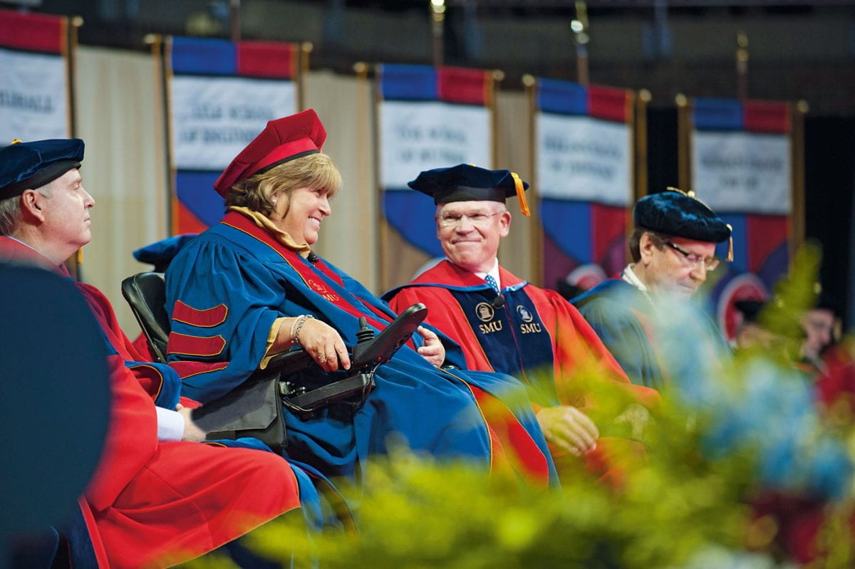 Rich and Mary Templeton sitting on stage and wearing graduation regalia