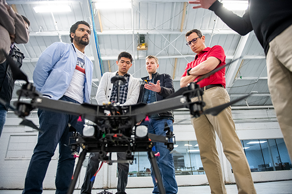 Students gather around a drone 